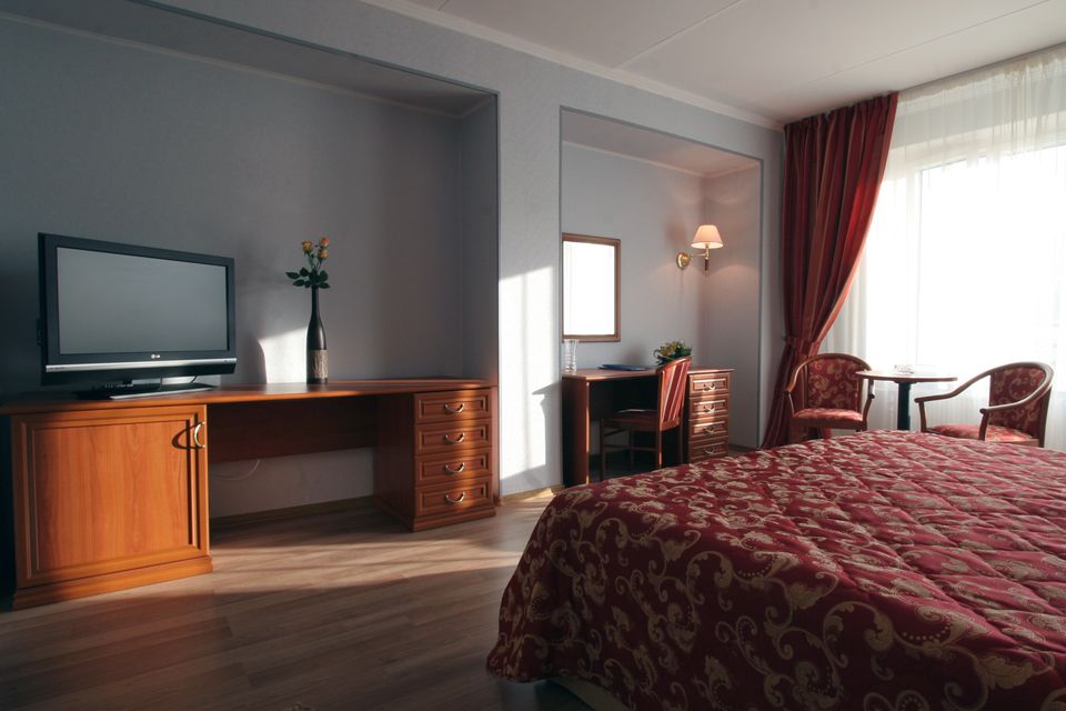 Кровать и стол в номере отеля